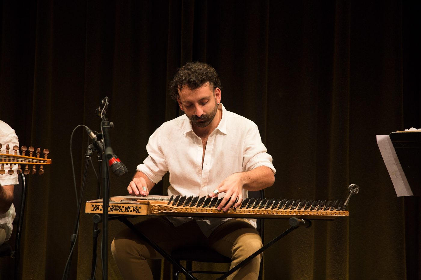 Camille playing a solo qanun set on a concert stage